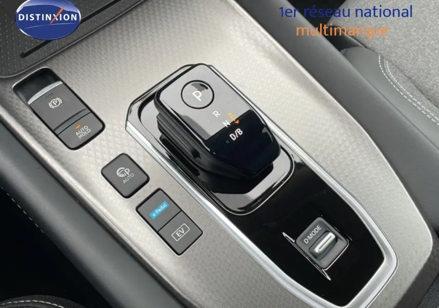 Gros plan sur la console centrale du Nissan Qashqai 2025, avec levier de vitesses noir brillant et boutons de commande.