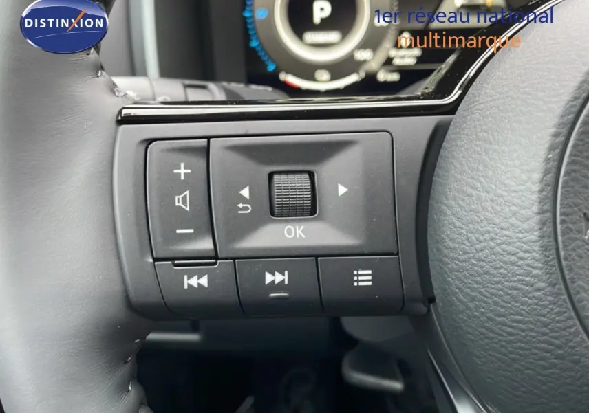 Gros plan sur les commandes au volant du Nissan Qashqai noir perle métal, mettant en valeur les boutons multifonctions et la molette OK.