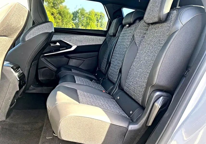 Vue latérale droite des sièges arrière en tissu gris et cuir noir du Peugeot 5008 Hybrid 145 allure e-dcs6 blanc.