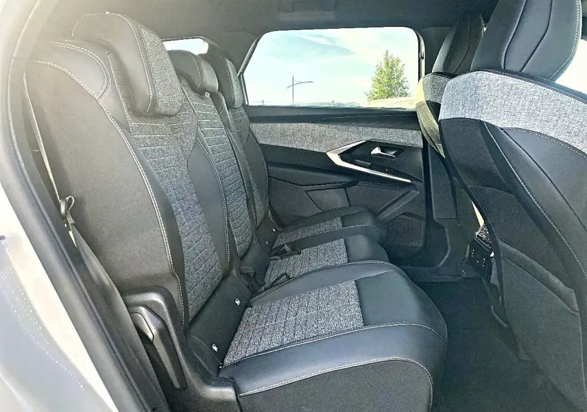 Vue intérieure côté gauche des sièges arrière en tissu gris et cuir noir du Peugeot 5008 Hybrid 145 allure e-dcs6 2025.