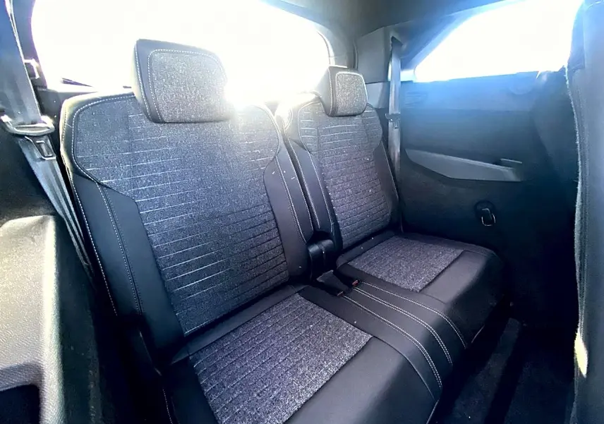Vue intérieure montrant les deux sièges arrière supplémentaires en tissu gris et noir du Peugeot 5008 Hybrid 145 allure 2025.