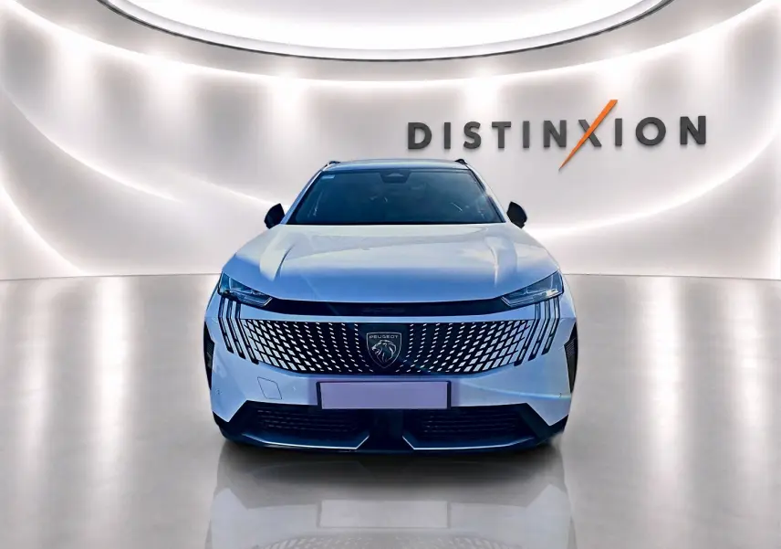 Vue avant d'un Peugeot 5008 blanc 2025 avec calandre distinctive et éclairage LED dans un showroom lumineux.
