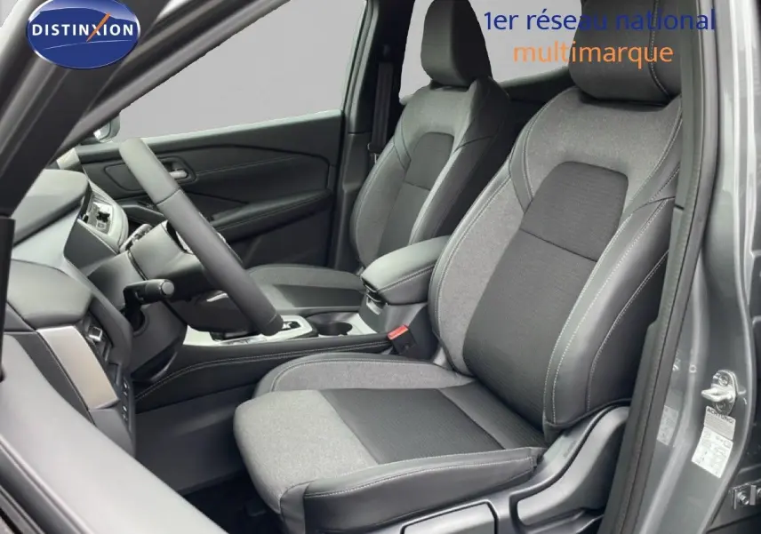 Vue intérieure côté conducteur du Nissan Qashqai 2025 gris squale métal, sièges tissu et cuir avec coutures contrastées.