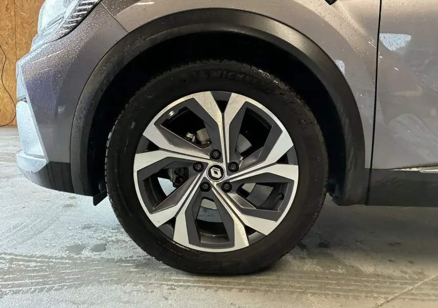 Gros plan sur l'aile avant gauche gris métallisé du Renault Captur 1.3 TCE 140 EDC RS Line avec détails de la carrosserie et du passage de roue.