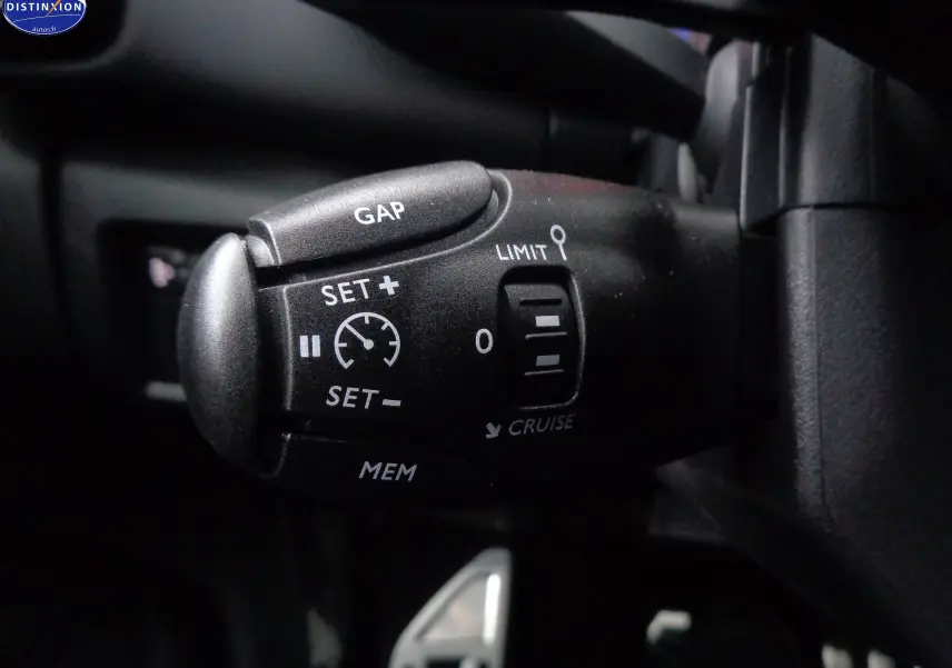 Gros plan sur la commande de régulateur de vitesse du Citroën C5 Aircross 2022, finition Shine, intérieur noir.