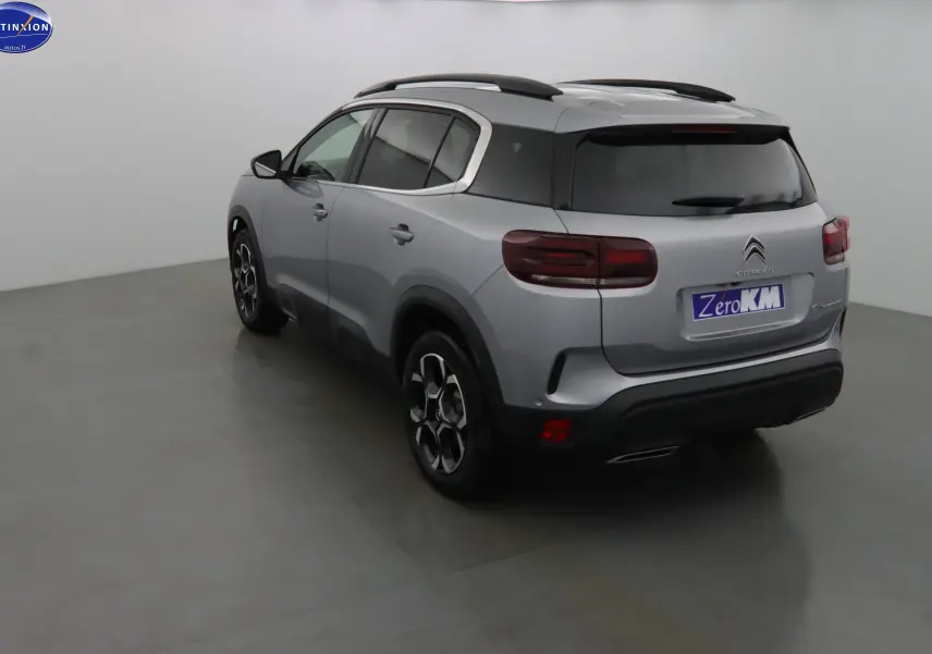 Vue 3/4 arrière droite d'un Citroën C5 Aircross gris Artense métal avec toit noir et jantes bi-ton.