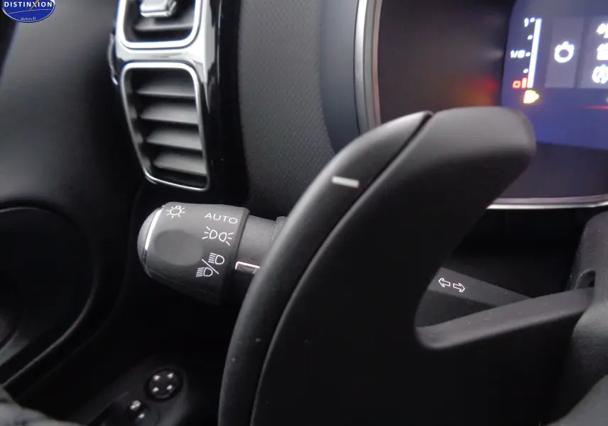 Gros plan sur la commande d'éclairage et le levier de vitesse au volant dans l'habitacle noir du Citroën C5 Aircross 2022.