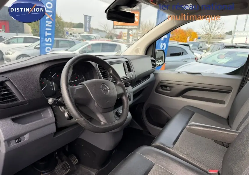 Intérieur avant droit de l'Opel Vivaro Fourgon gris, montrant le tableau de bord et le volant multifonction.