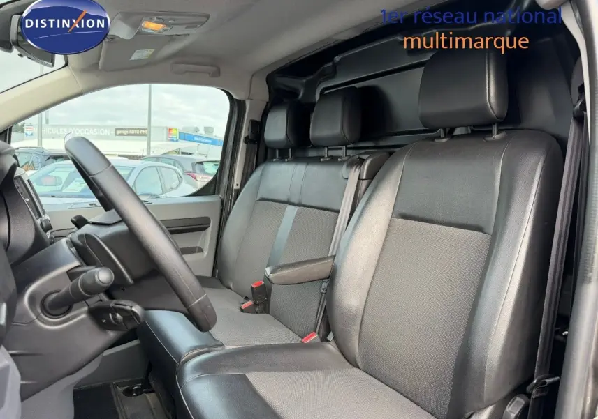 Vue intérieure côté conducteur de l'Opel Vivaro Fourgon 2020 avec sièges en cuir et tissu gris.