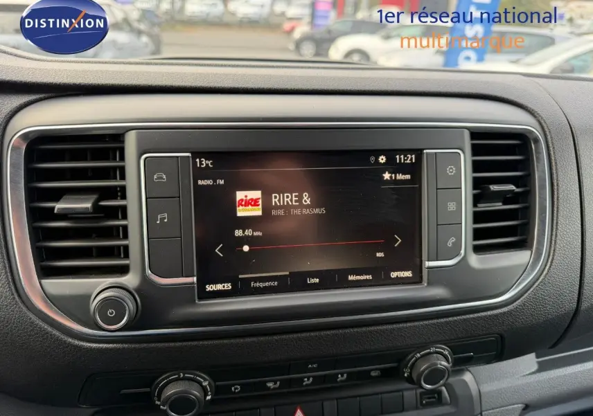 Tableau de bord de l'Opel Vivaro Fourgon gris Pierre de Lune, avec écran tactile central affichant une radio FM.