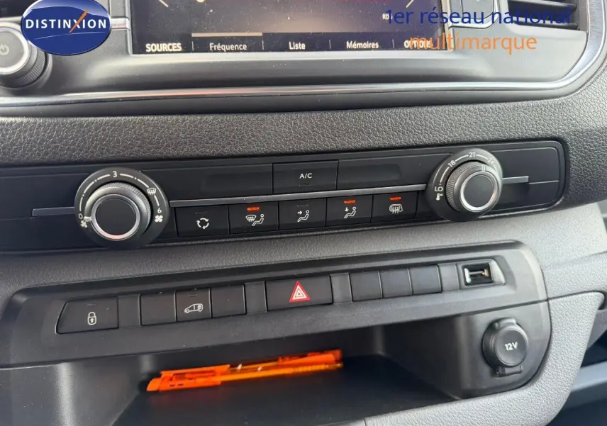 Vue rapprochée du tableau de bord de l'Opel Vivaro Fourgon gris, montrant les commandes de climatisation et les boutons de sécurité.