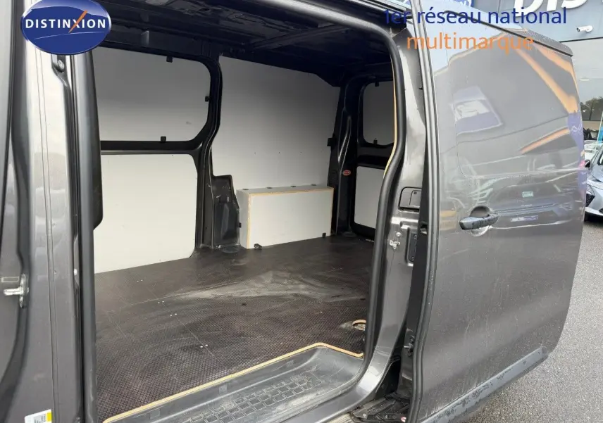 Vue côté droit du fourgon Opel Vivaro M 2.0 CDTI 180 BVA Business gris Pierre de Lune métallisé avec porte coulissante ouverte montrant l'espace de chargement vide.