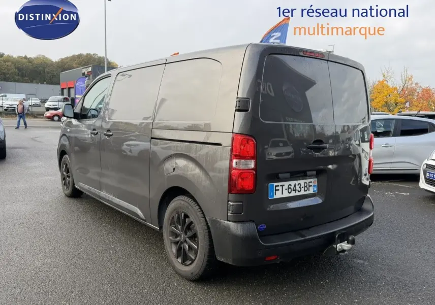Opel Vivaro Fourgon gris Pierre de Lune métallisé vu en 3/4 arrière droit avec attelage et jantes noires.