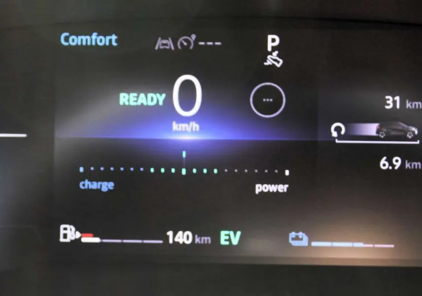 Tableau de bord numérique du Renault Captur 2025 affichant la vitesse à zéro et l'autonomie hybride en mode confort.