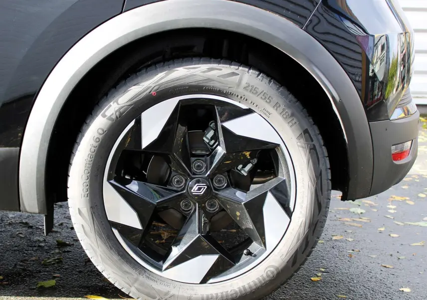 Gros plan sur la roue arrière droite du Renault Captur noir métal avec jante biton noire et argentée design étoile.