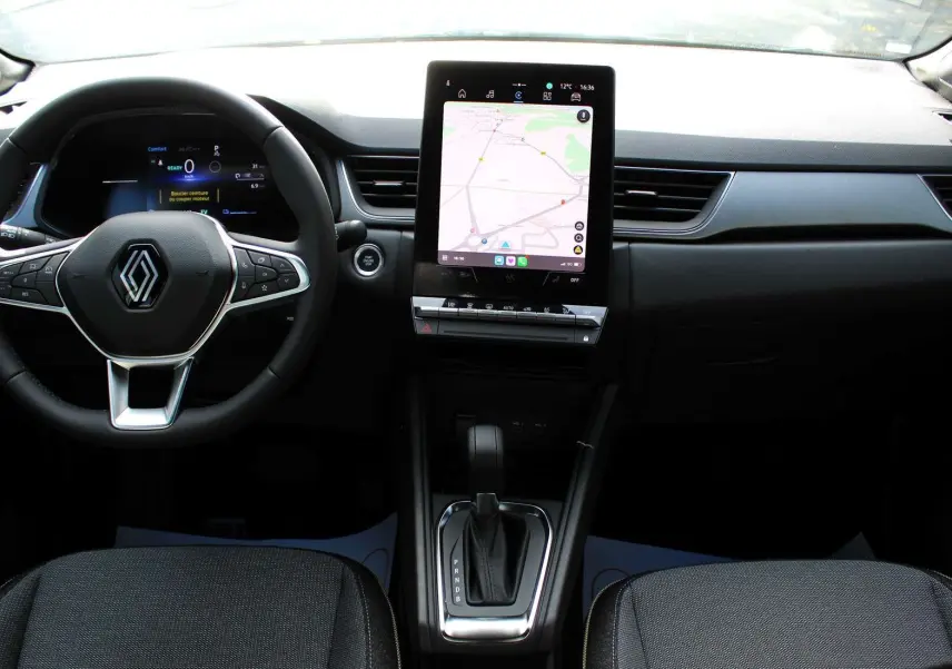 Intérieur du Renault Captur 2025, vue de face sur le volant, écran tactile central et console de boîte automatique.