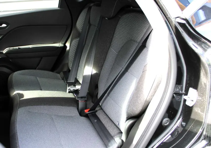 Vue intérieure côté droit des sièges arrière gris du Renault Captur 2025 noir métal avec ceinture de sécurité.