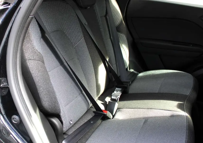 Vue intérieure des sièges arrière gris foncé du Renault Captur 2025, avec ceintures de sécurité noires visibles.
