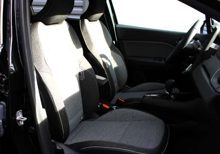 Intérieur du Renault Captur 2025 vu côté gauche, sièges tissu gris et noir avec surpiqûres contrastées.