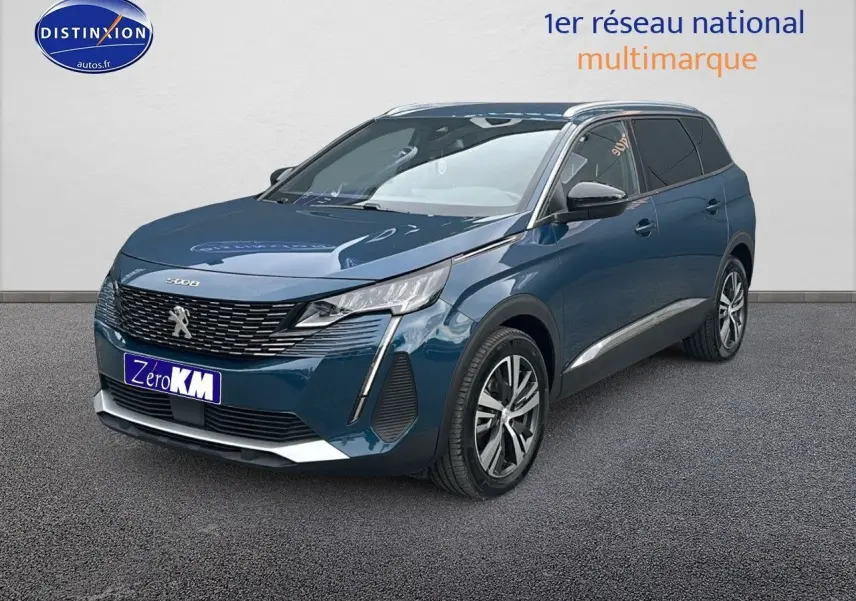 Peugeot 5008 bleu en 3/4 avant droit avec calandre chromée et jantes alliage 18 pouces visibles.