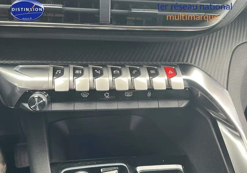 Gros plan sur la console centrale du Peugeot 5008 bleu 2024, mettant en valeur les commandes chromées et le design carbone.
