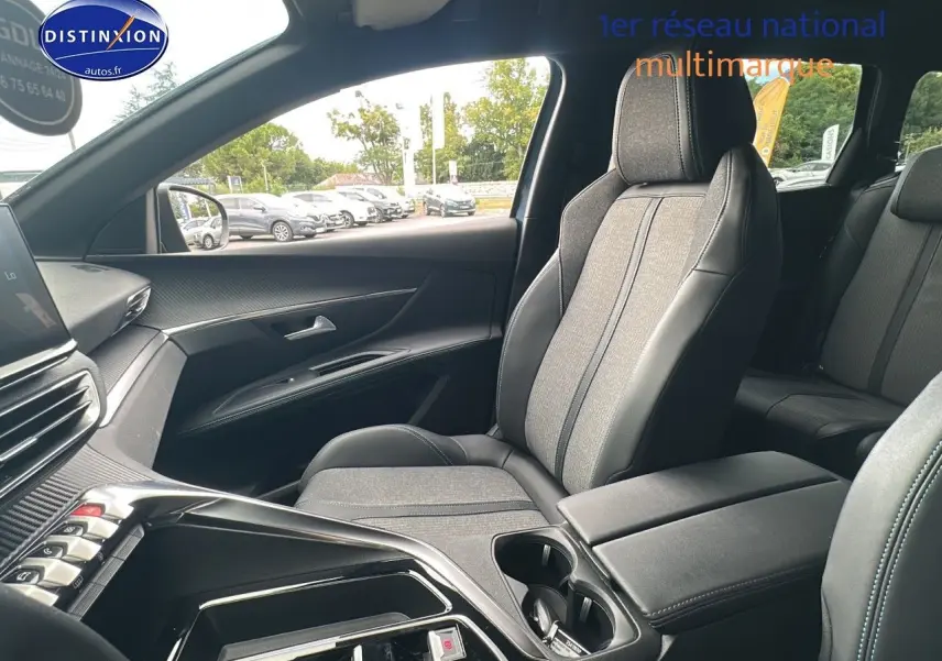 Intérieur du PEUGEOT 5008 2024 côté passager, sièges TEP gris et console centrale avec rangements et porte-gobelets.