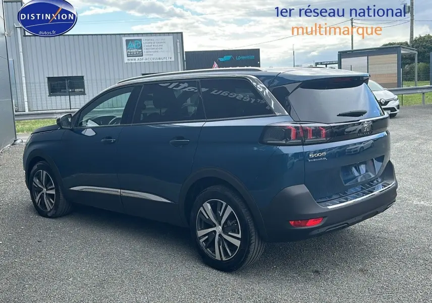 Peugeot 5008 bleu vue 3/4 arrière droit avec feux LED 3D et vitres arrière surteintées.