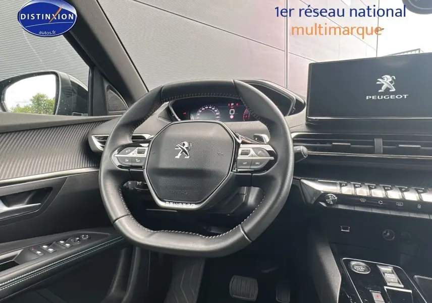 Vue intérieure centrée sur le volant cuir noir et le tableau de bord numérique du Peugeot 5008 bleu 2024.