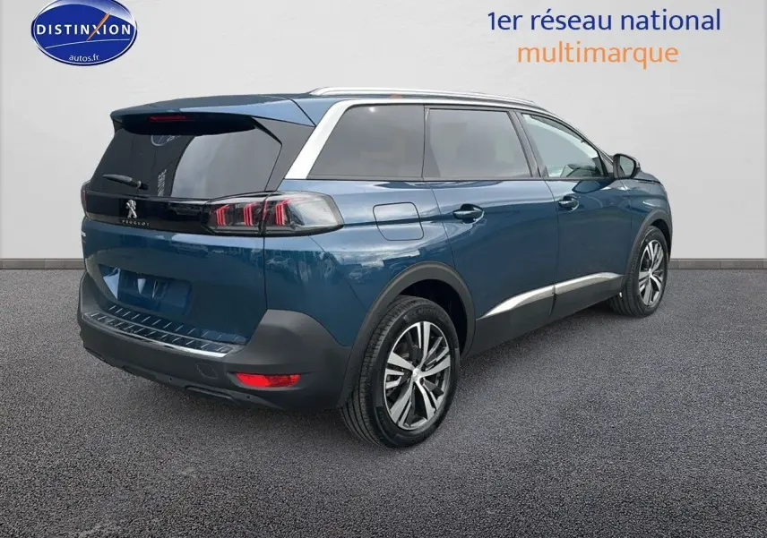 Peugeot 5008 bleu en 3/4 arrière droit, avec vitres teintées et jantes alliage 18 pouces.
