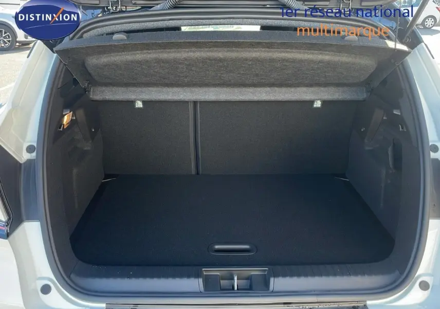 Coffre ouvert du Renault Captur E-Tech blanc nacré avec toit noir, vue arrière montrant l'espace de chargement vide.