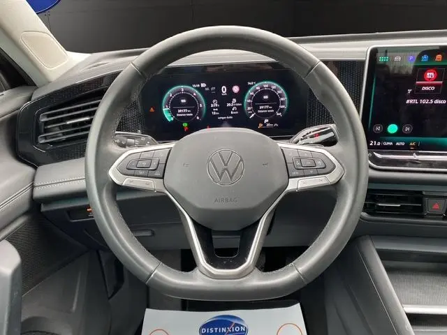 Vue frontale du volant noir du Volkswagen Tiguan 2024 avec tableau de bord numérique et écran tactile central allumé.