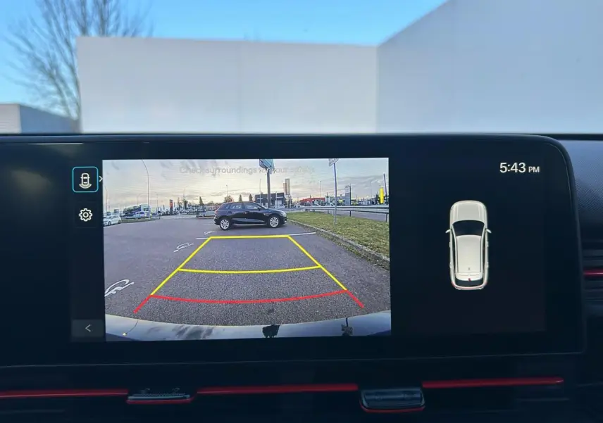 Vue caméra de recul montrant un Hyundai Kona noir Abyss Metal garé de profil côté droit sur un parking.