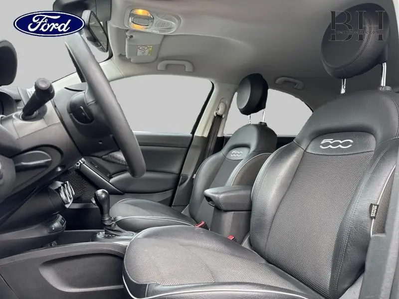 Vue intérieure côté conducteur de la Fiat 500X 2017 avec sièges en tissu gris et cuir noir embossé 500.