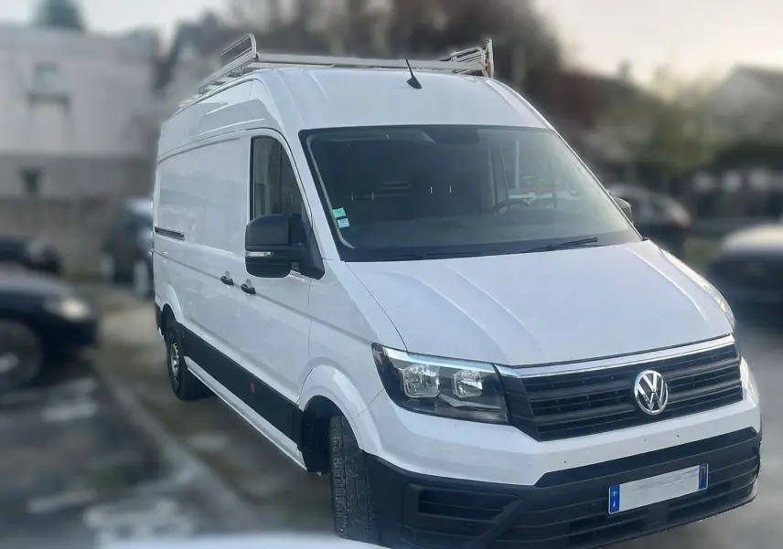 Volkswagen Crafter blanc en 3/4 avant droit, fourgon utilitaire avec galerie de toit et rétroviseurs noirs.