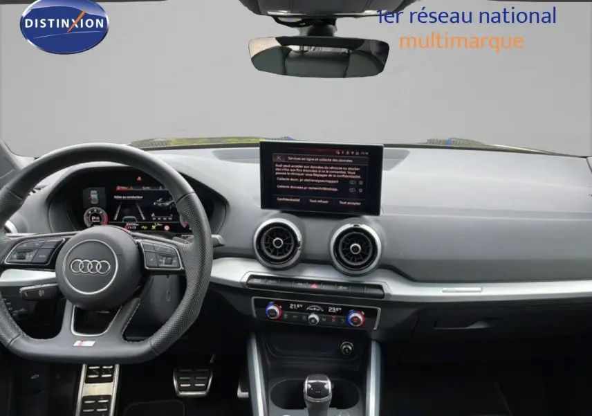 Vue intérieure frontale de l'Audi Q2 2025 noir mito metal, avec tableau de bord numérique et écran central tactile.