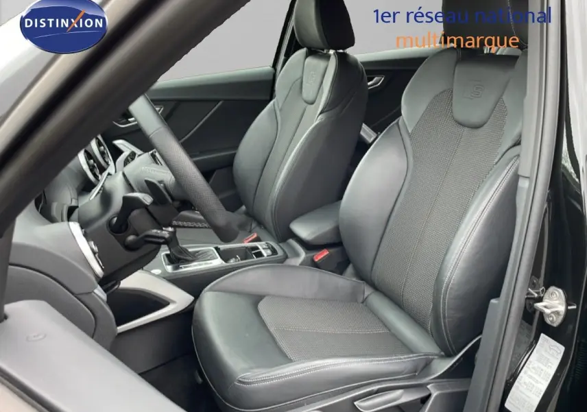 Vue intérieure côté conducteur de l'Audi Q2 noir mito metal, sièges sport en cuir avec logo S intégrés.