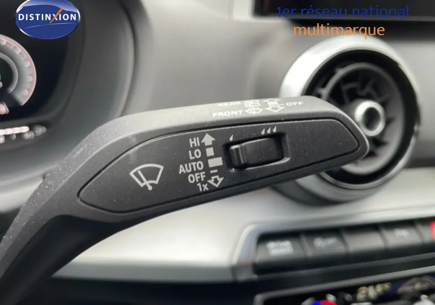 Gros plan sur la commande des essuie-glaces à l'intérieur d'un Audi Q2 noir mito metal, tableau de bord en arrière-plan flou.