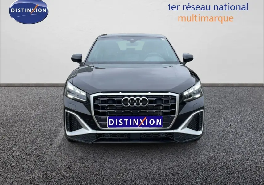 Vue frontale d'un Audi Q2 noir mito metal 2025 avec calandre hexagonale et phares LED allumés.
