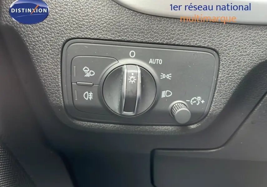 Gros plan sur la commande des phares d’un Audi Q2 35 2.0 TDI S-Line, intérieur noir texturé.