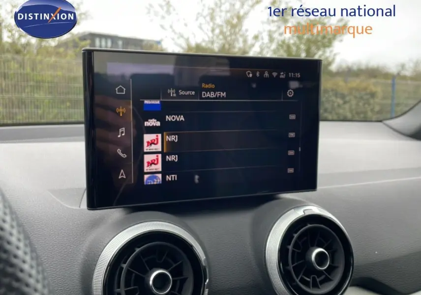 Écran tactile central affichant les radios DAB/FM dans l’habitacle d’un Audi Q2 noir mito metal.