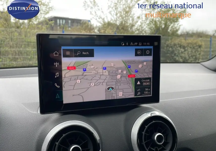 Vue intérieure de l'Audi Q2 2025 montrant l'écran central avec navigation et les aérateurs ronds du tableau de bord.