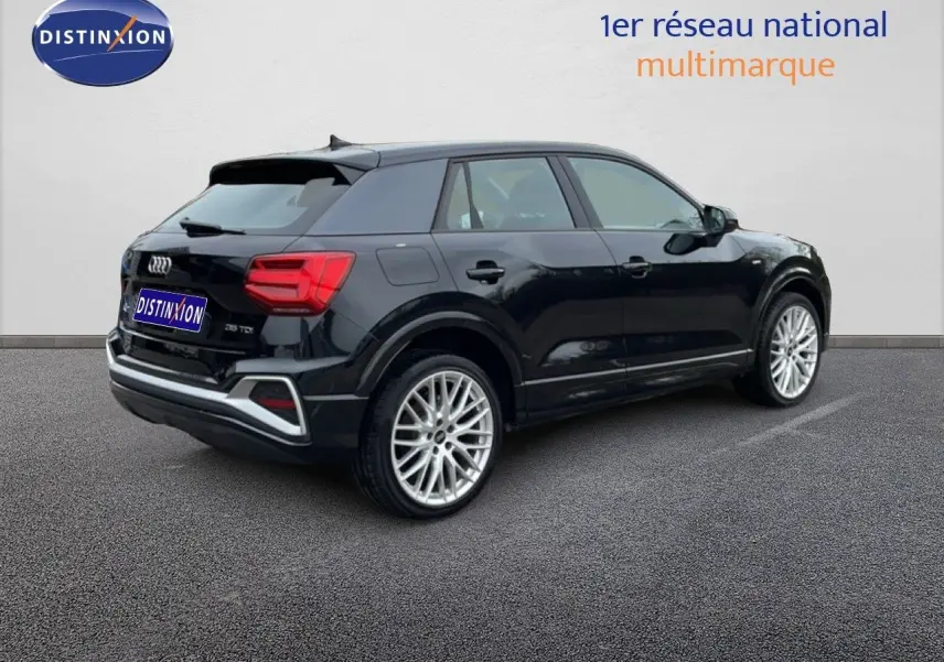 Audi Q2 noir mito metal vue 3/4 arrière droit, jantes alliage et feux arrière LED visibles.