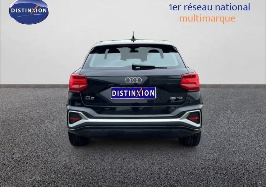 Vue arrière d'un Audi Q2 noir mito metal 2025 avec feux rouges et logo distinctif sur fond neutre.