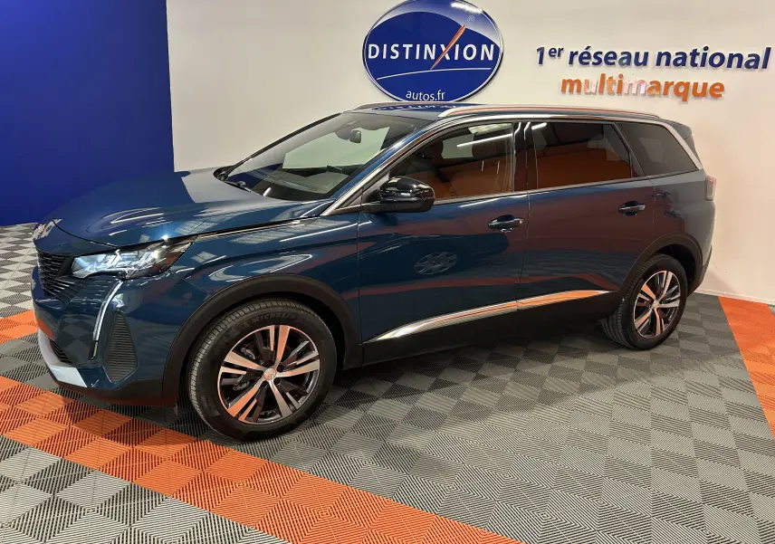 Peugeot 5008 bleu Célèbes en vue 3/4 avant droit, avec jantes alliage et intérieur marron visible.
