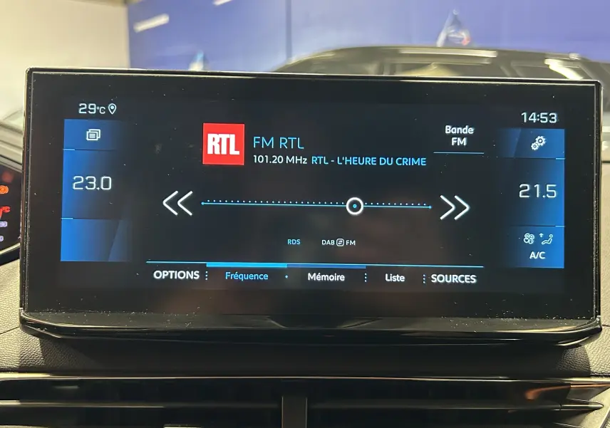 Écran tactile central du Peugeot 5008 2024 affichant la radio FM RTL et la climatisation en intérieur noir.