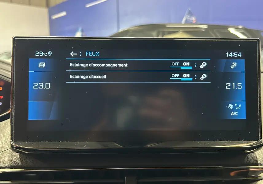 Écran tactile central du Peugeot 5008 2024 affichant les réglages des feux avec climatisation à 23°C et 21,5°C.