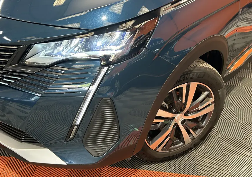 Gros plan sur l'avant droit bleu Célèbes du Peugeot 5008 II Ph.2 avec phares LED et jante alliage distinctive.