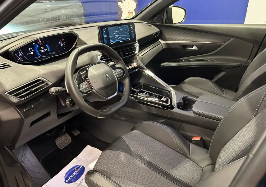 Intérieur avant droit du Peugeot 5008 2024, tableau de bord numérique et écran tactile central avec sellerie noire.