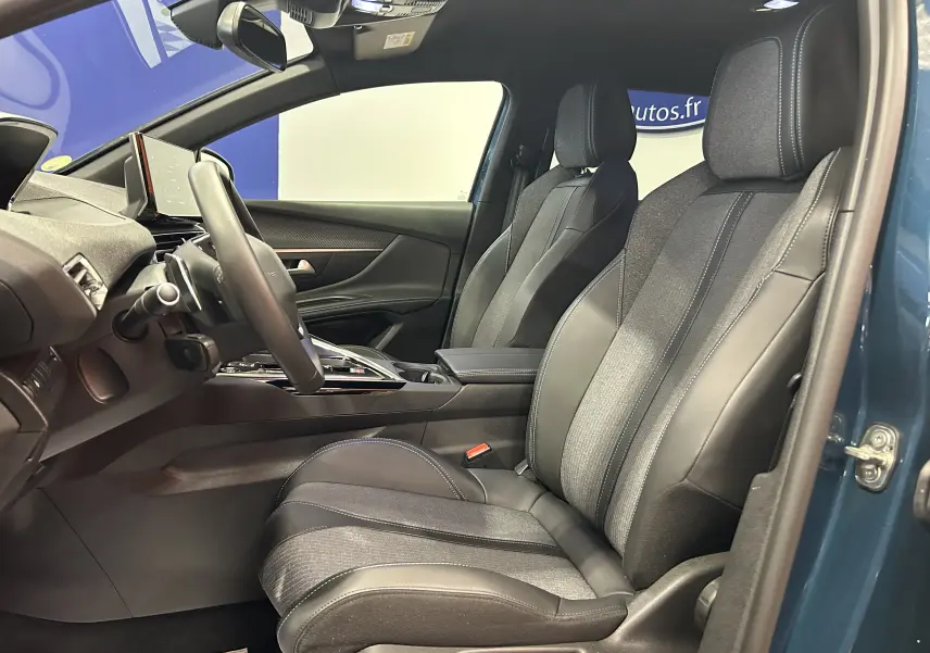 Vue intérieure côté gauche du Peugeot 5008 bleu Célèbes, mettant en valeur les sièges avant en cuir et tissu avec surpiqûres contrastantes.