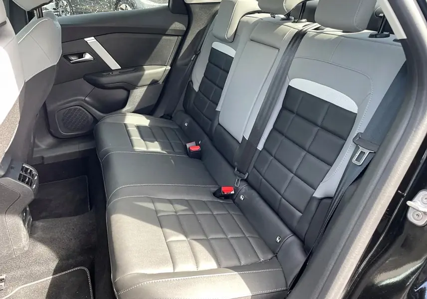 Vue côté droit de la banquette arrière bi-ton noir et gris clair du Citroën C4 X 1.2 hybride 2025, avec ceinture de sécurité visible.